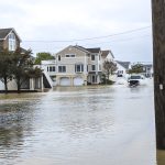 A van navigates a flooded roadway in Ship Bottom, NJ