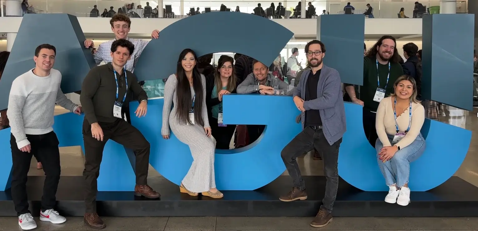 Joshua's research group gathered around the AGU logo near the entrance of the building.