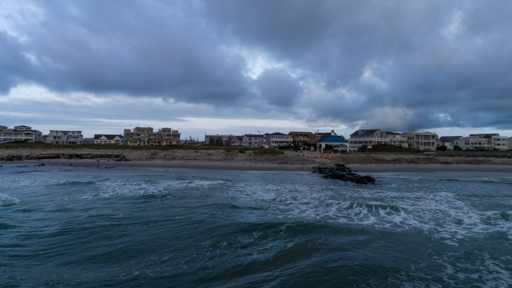 Stormy ocean shore with a view of hotels and condos from over the water