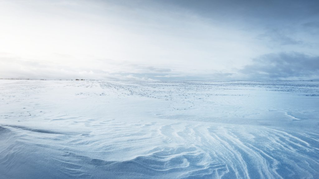 Wide snow-covered field in Lapland, Finland on a partly clear day