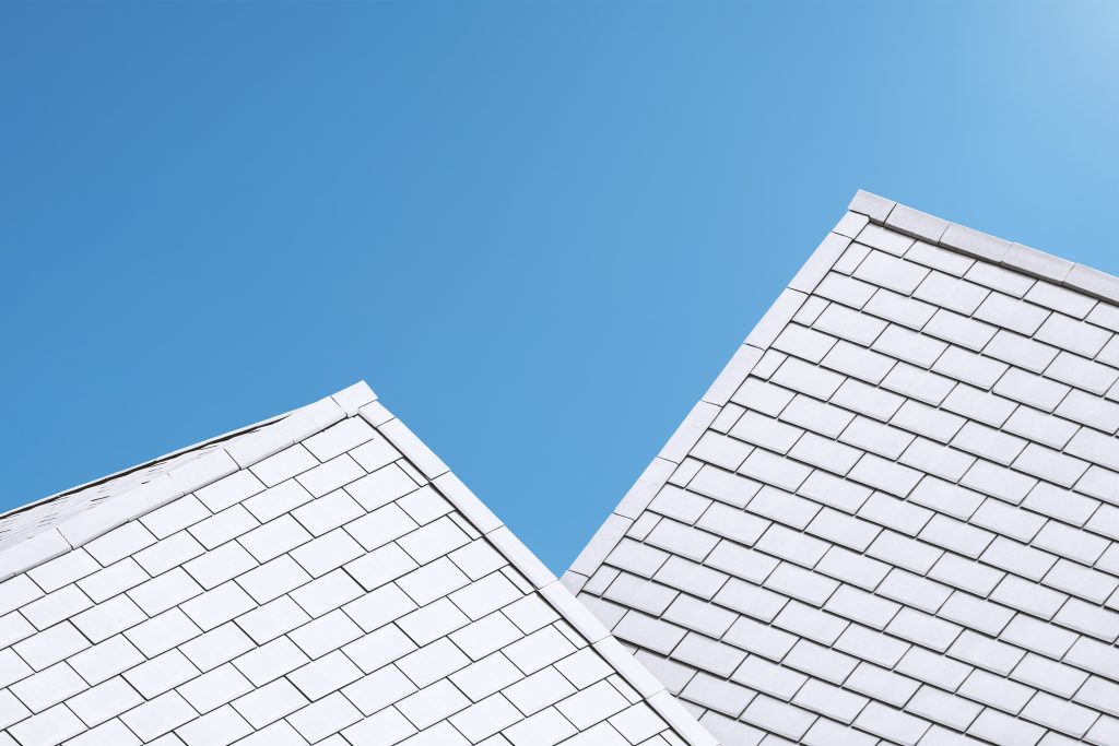 White paneled roofs against a clear blue sky