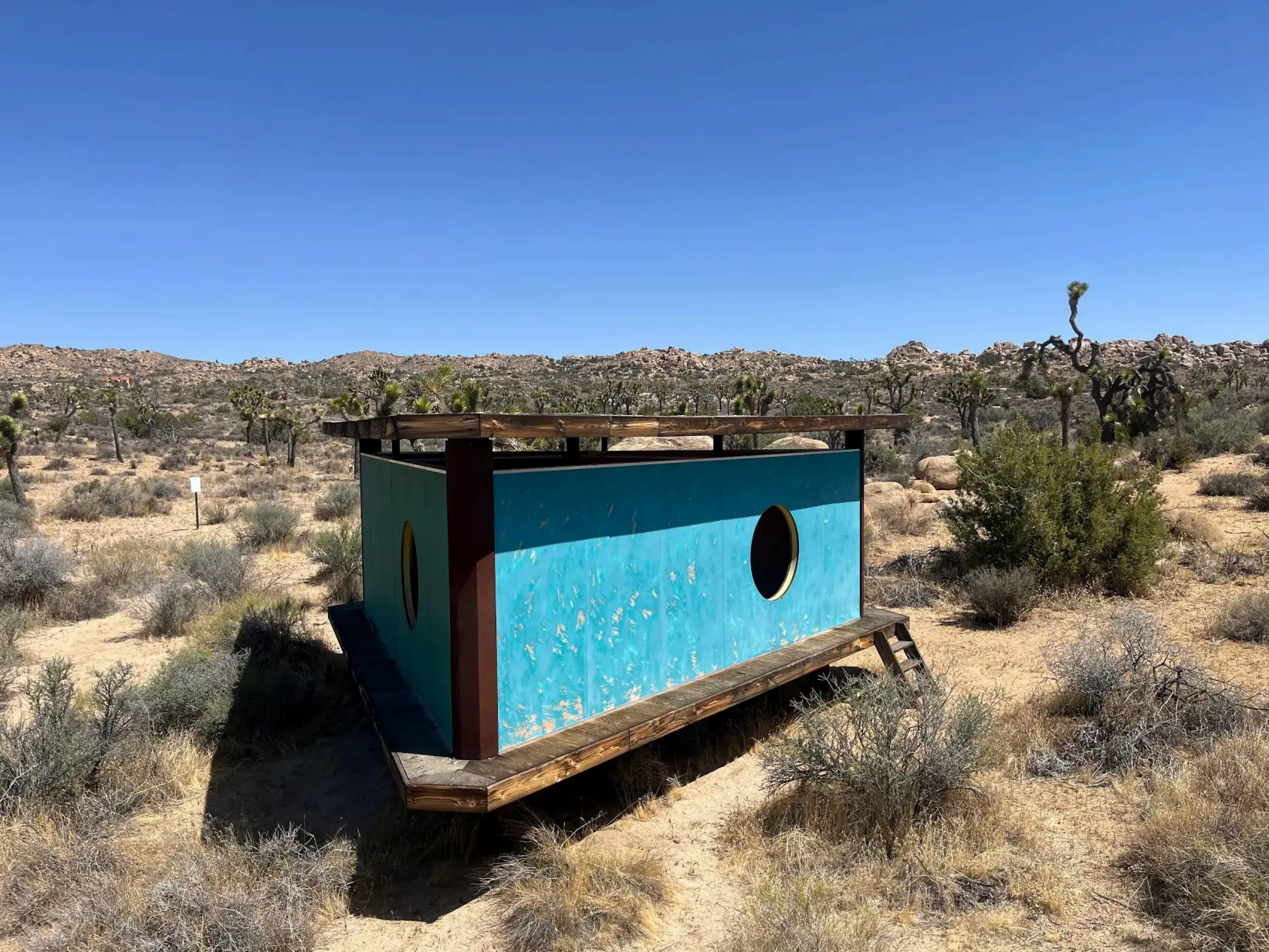 Image of installation, a blue wooden structure, in Joshua Tree.