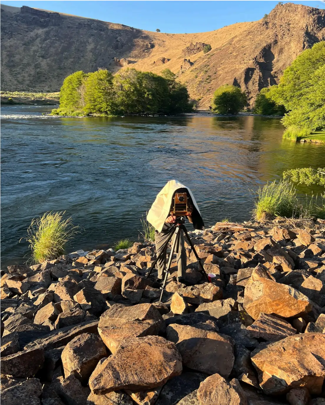 Image of Andrew Jarman near a camera along the Deschutes River.