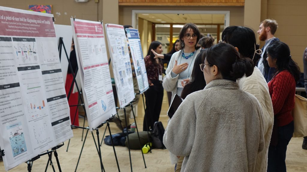 Poster presenters and attendees exchanging ideas and insights during the session.