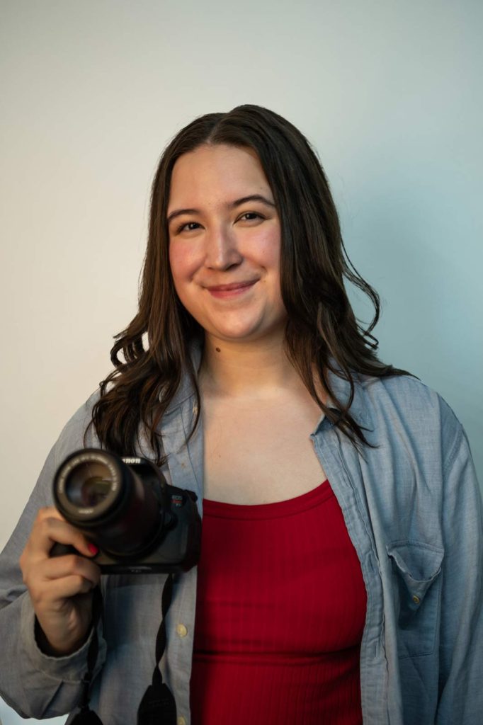 Photo of Kimberly Hansen holding up a camera