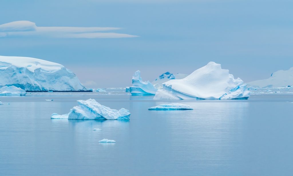 Blue ocean with view of several glaciers and masses of ice in the water