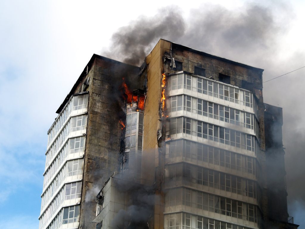 Skyscraper on fire, smoke and flames poking out of the top