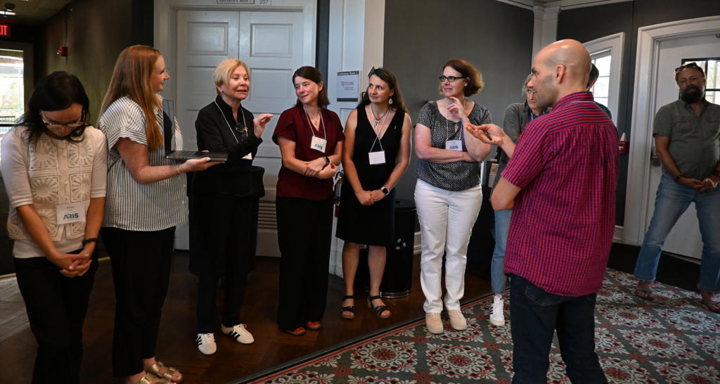 Participants stand in a semi circle, listening to each other talk during the exercise